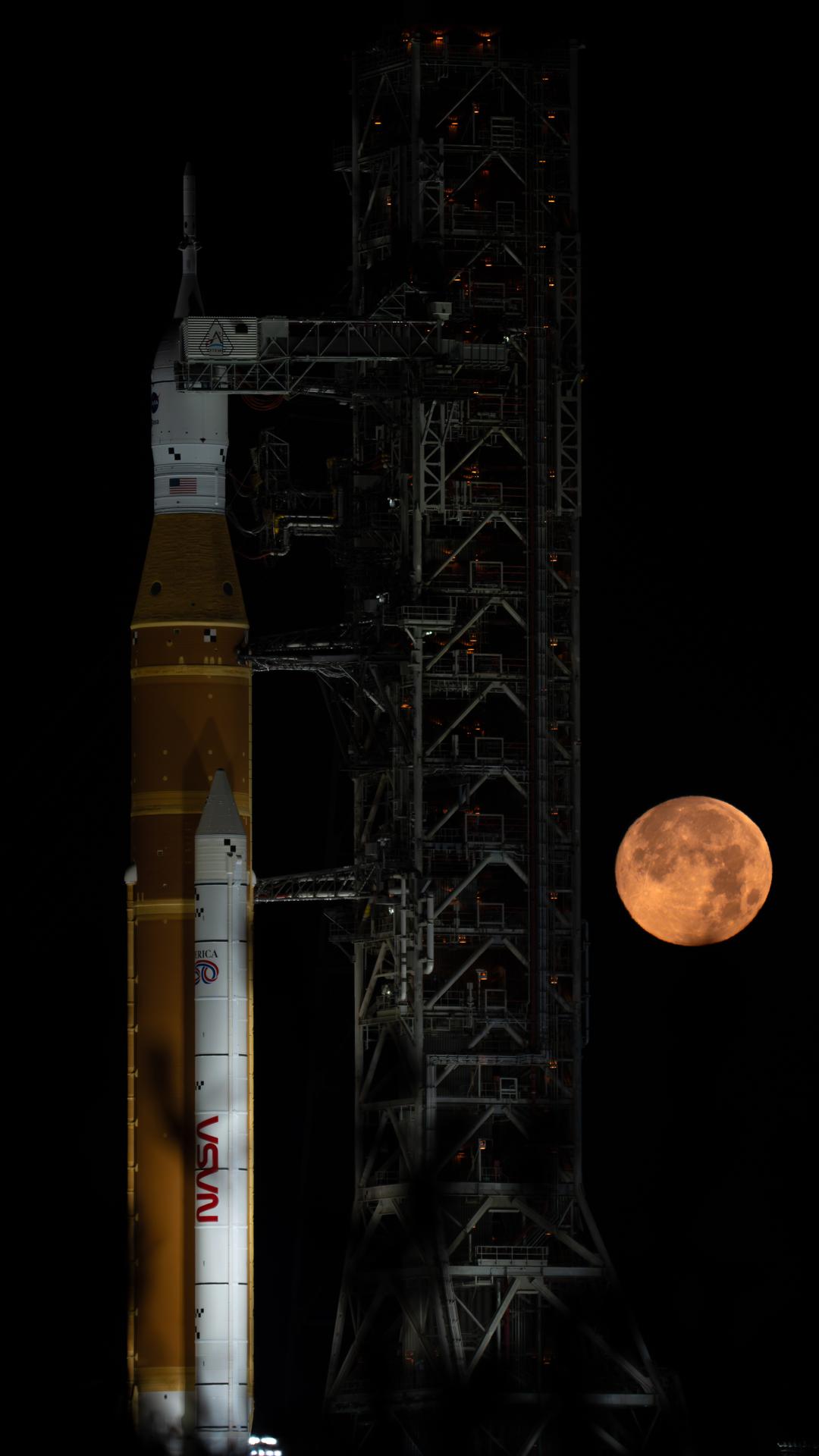 A full Moon is seen shining over NASA’s SLS (Space Launch System) and Orion spacecraft, atop the mobile launcher in the early hours of February 1, 2026. The rocket is currently at Launch Pad 39B at NASA’s Kennedy Space Center in Florida, as teams are preparing for a wet dress rehearsal to practice timelines and procedures for the launch of Artemis II.